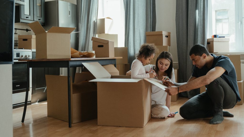 A family packing moving boxes in a kitchen