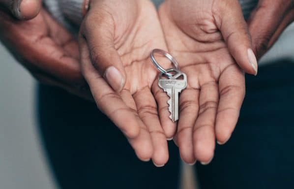 A couple holds a key after selling their house for cash. Ways to know if you should accept a cash offer.