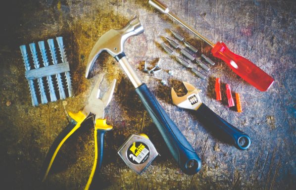 A hammer tape measure screwdriver pliers and other tools used in repairing a house before selling.