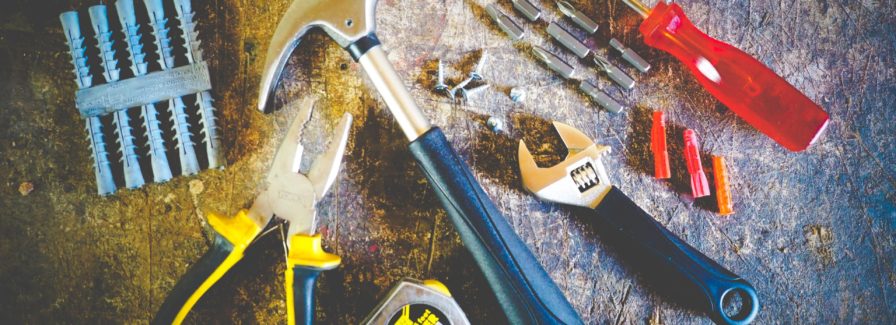 A hammer tape measure screwdriver pliers and other tools used in repairing a house before selling.